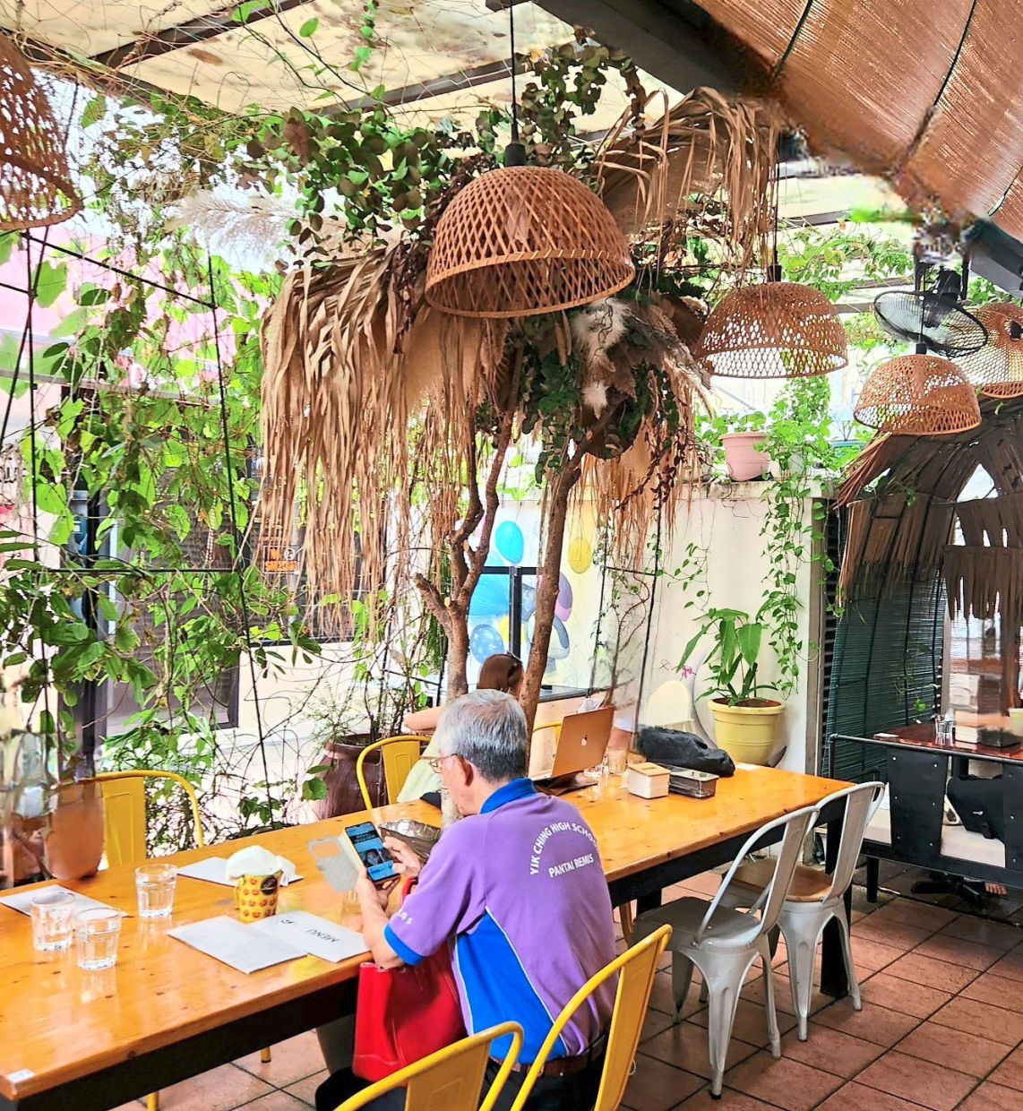The greenery and hanging baskets give the cafe an inviting tropical setting.
